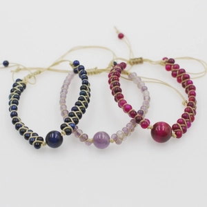 Detail of three layers of handmade woven natural stone bead bracelets with adjustable cord