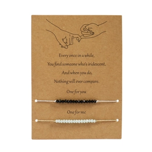 Detail of adjustable couple bracelets with glass beads and pink promise illustration card