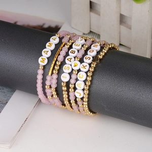 Dettaglio di bracciali a strati con perline MAMA e nomi personalizzati su espositore
