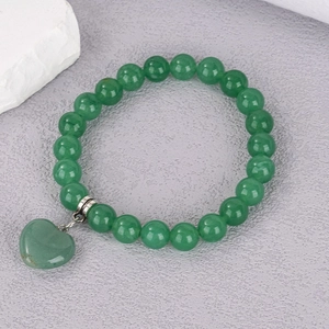 Close-up of 8mm green crystal beaded bracelet with a translucent heart-shaped stone pendant