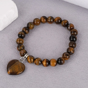 Detail of 8mm tiger eye beaded bracelet featuring a polished heart-shaped gemstone charm