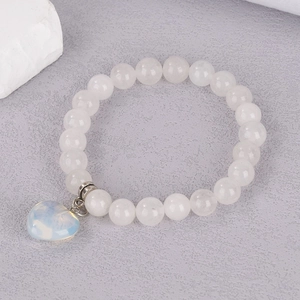 Detailed view of 8mm white crystal beaded bracelet with heart opal stone pendant