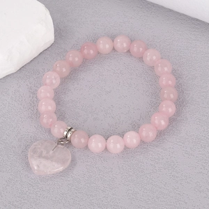 Detail of 8mm rose quartz beaded bracelet featuring a heart-shaped gemstone pendant