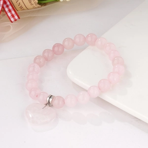 8mm green crystal stretch bead bracelet with heart pendant on a white ceramic display