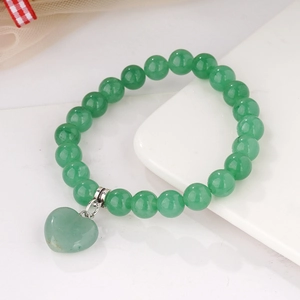 Green 8mm crystal beaded elastic bracelet with heart pendant on white pedestal