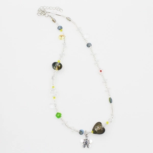 Detail of beaded necklace with colorful glass charms and a silver flower pendant
