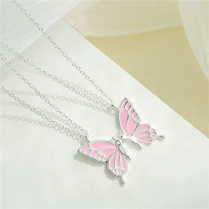 Detail shot of paired pink butterfly necklaces with silver-tone chains for best friends