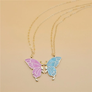 Detail of butterfly friendship necklaces with pink and blue enamel wings on gold chains
