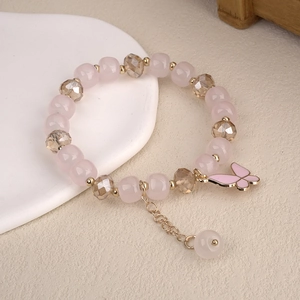 Close-up of beaded bracelet with pink crystal beads and a butterfly charm detail