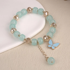 Detail of beaded bracelet with blue square beads, crystal charms, and butterfly pendant