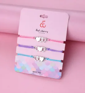 Set di tre braccialetti cuore per sorelle in rosa, viola e blu su cartoncino