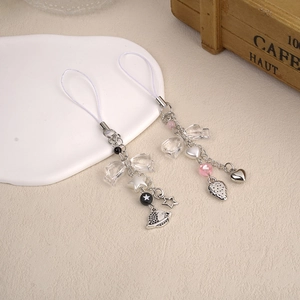 Détail de bijoux de téléphone faits main avec perles et pendentifs étoile et fraise
