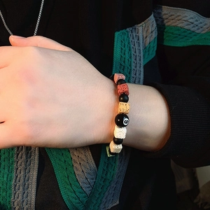 Macro detail of elastic beaded bracelet with colorful volcanic stone and billiard eight ball