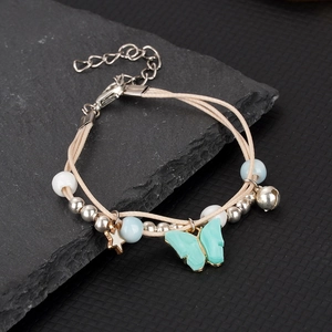 Detail of nautical braided bracelet featuring turquoise butterfly charm and silver bell