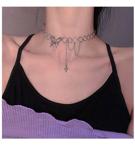 Detail of silver butterfly choker with fringe and star pendant worn by a model