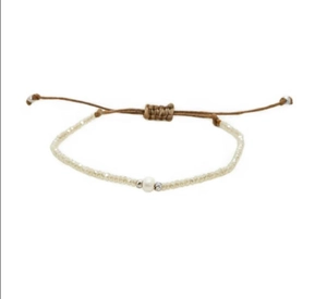 Detail van de handgeweven armband met champagne kralen en een zoetwaterparel in het midden