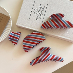 Set elegante di mollette per capelli a righe rosse, bianche e blu su uno sfondo minimalista