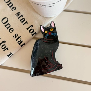 Detailed view of a cute black cat claw clip made of acetic acid with marble texture