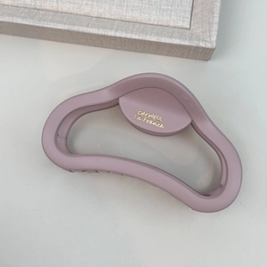 Macro detail of matte mauve hair claw clip featuring golden Barrette La France text