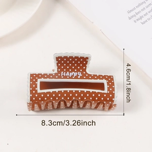 Vue détaillée d'une pince à cheveux marron à pois avec texte Happy et dimensions