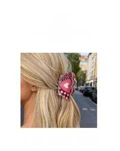 Gros plan d'une grande pince à cheveux rose léopard en forme de cœur portée dehors