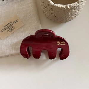 Detail of burgundy glossy hair claw with gold lettering Barrette LaFrance text