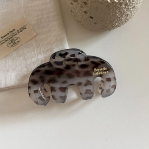Detailed close-up of leopard print hair claw clip with golden Barrette La France lettering