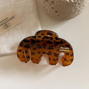Detail of tortoise shell claw clip with arc design and gold Barrette LaFrance logo