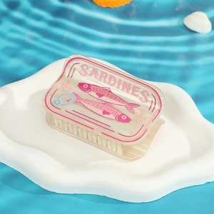 Gros plan d'une pince à cheveux créative en forme de boîte de sardines au fini translucide