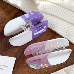 Set of two colorful marble acrylic hair claws in purple and pink for women's hairstyles