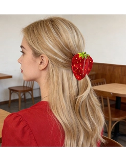 Pince à cheveux fraise rouge mignonne portée sur cheveux blonds dans un café