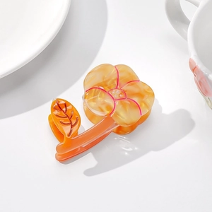 Détail de la pince à cheveux fleur ambre translucide avec design de pétale en acétate