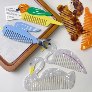 Chic animal-shaped acetate hair combs with marble patterns on a rustic wooden tray