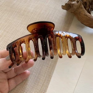 Close-up of large amber tortoiseshell hair claw clip with glossy acrylic finish