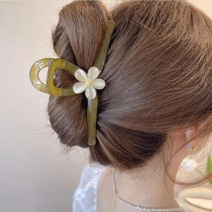 Pince à cheveux fleur vert olive en acétate portée en chignon par un mannequin
