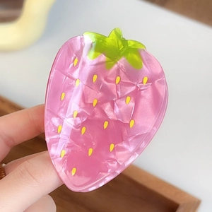 Détail d'une pince à cheveux fraise rose en acétate avec feuille verte et pépins
