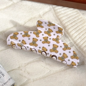 Detail of lavender floral hair claw clip featuring cute teddy bear patterns on a knit background