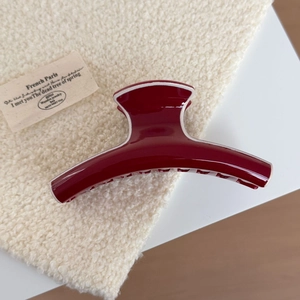 Close-up of a large dark red hair claw clip with elegant white lining and glossy finish