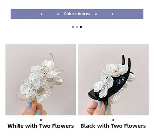 Dettaglio delle mollette per capelli a doppio fiore in bianco e nero con strass