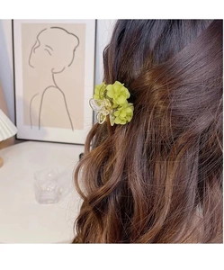 Détail de la pince à cheveux muguet vert clair sur la coiffure d'un modèle