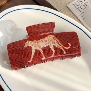 Gros plan d'une grande pince à cheveux motif léopard sur une assiette en céramique