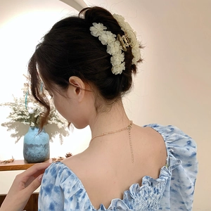 Pince à cheveux élégante avec fleurs de muguet crème sur un modèle féminin