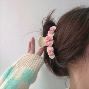 Pince à cheveux avec nœuds roses et ours, portée sur cheveux bruns pour un look mignon