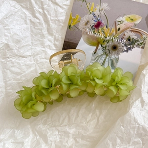 Détail de la pince à cheveux muguet vert sur fond de papier texturé blanc élégant
