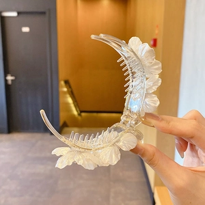Macro di una grande clip per capelli trasparente con decorazioni floreali perlescenti