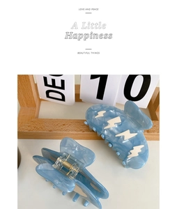 Detail of light blue marble acetate hair claw clips with lightning pattern and metal spring