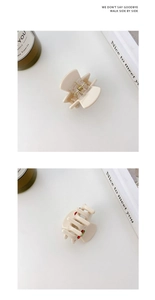 Macro detail of creamy white acetate hair claw clip featuring 3D cherry accents