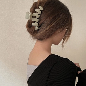 Matte bean green geometric shark hair claw clip for elegant bun hairstyle on a model