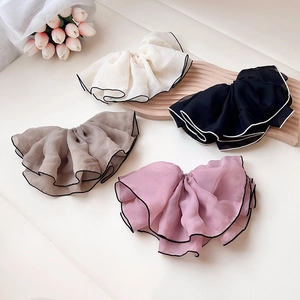 Dettaglio di elastici scrunchie giganti in rete in quattro colori con bordi a contrasto