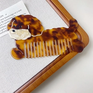 Close-up of cute cartoon dog hair comb with tortoise shell texture and acetate finish